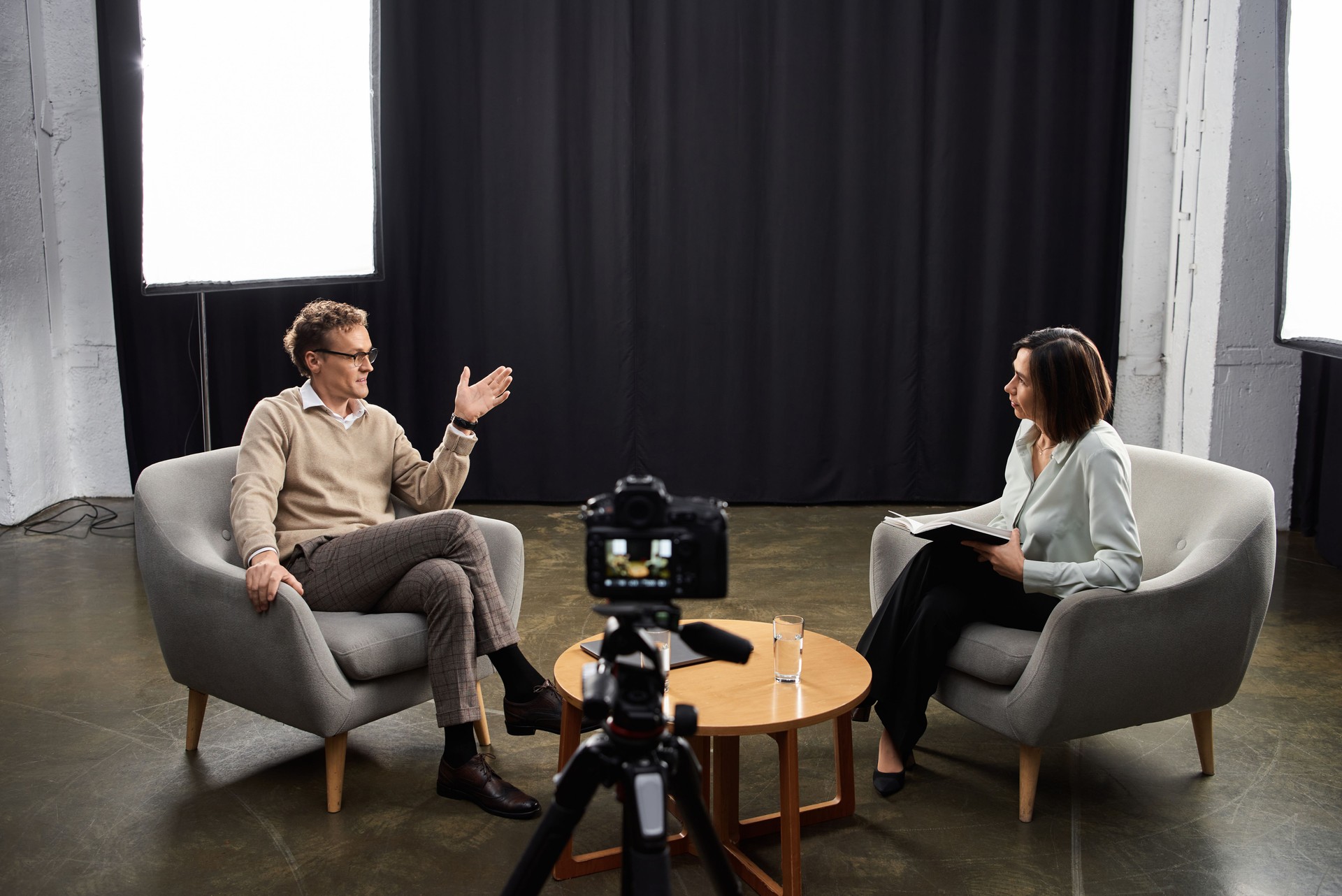 Engaging dialogue between journalist and guest in a cozy studio podcast setting