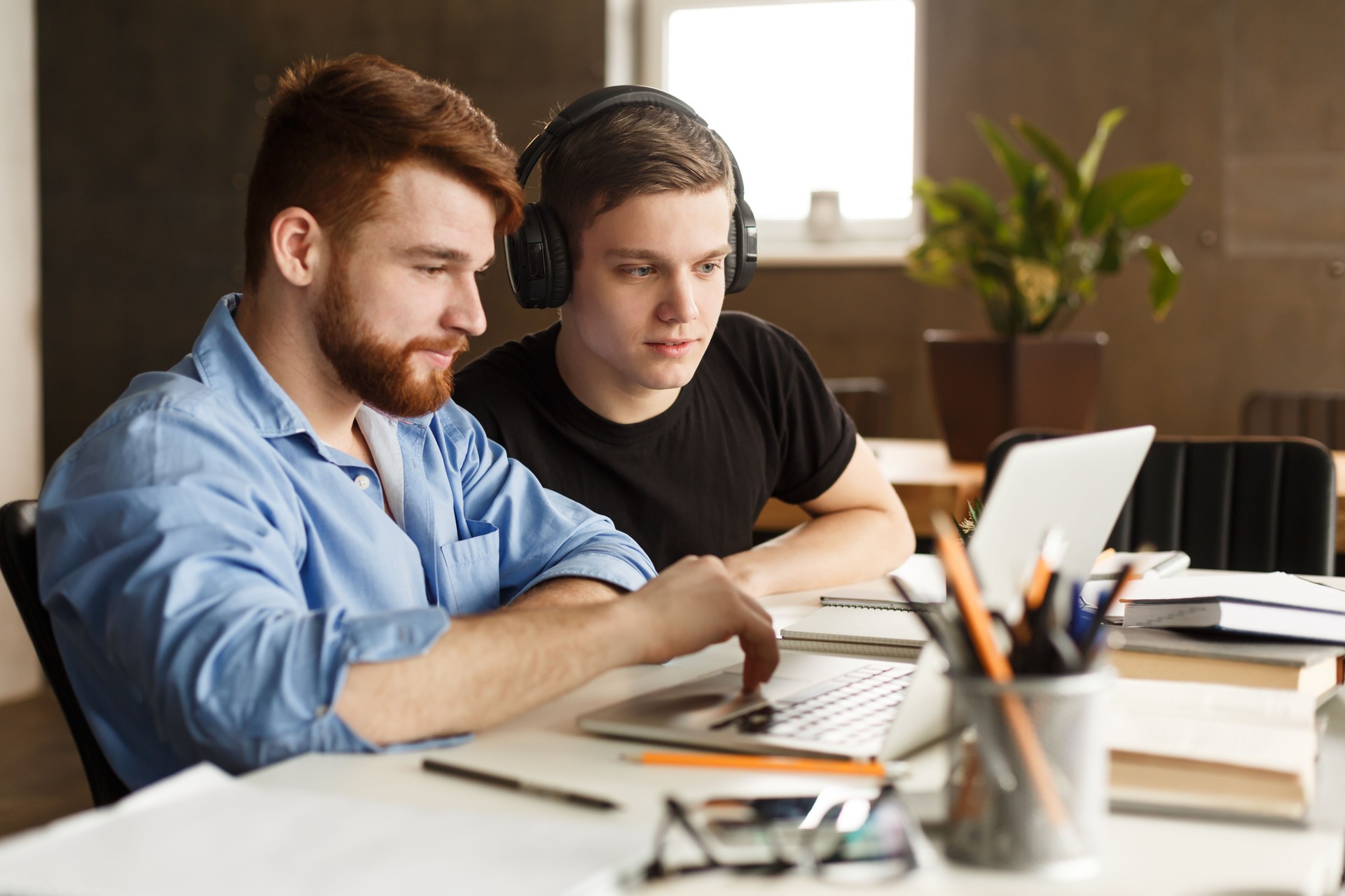 Two Young Men Collaborating on a Project at a Bright Indoor Workspace During the Day
