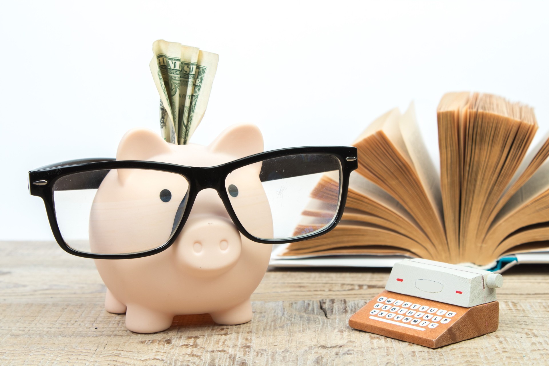 Piggy bank in glasses and books on white background. open book. Tuition payment. Brainwork. Typewriter. The concept of literary creativity. Back to school.